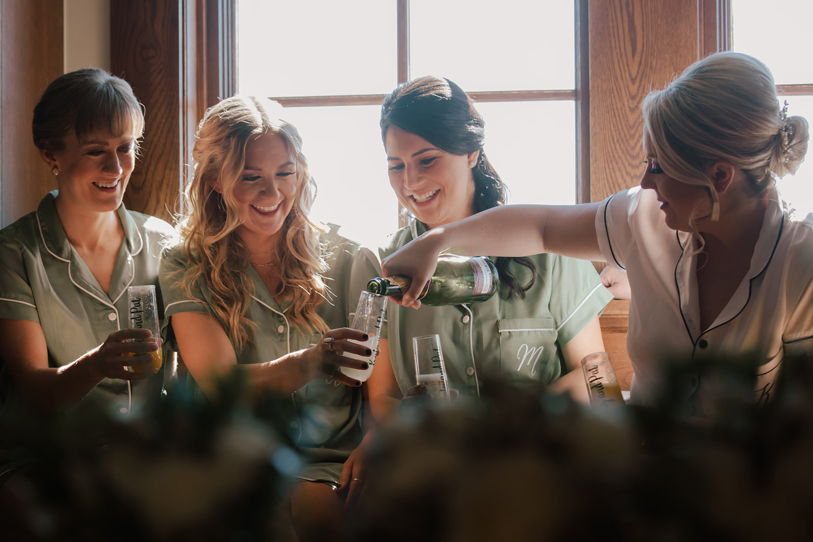 Bridesmaids laughing over champagne while getting ready at a Fredericksburg wedding by GR Weddings