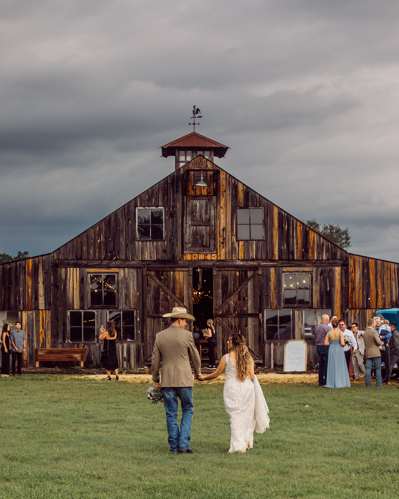 Bride and groom walking to the barn at The 1850 Settlement near San Antonio by GR Weddings