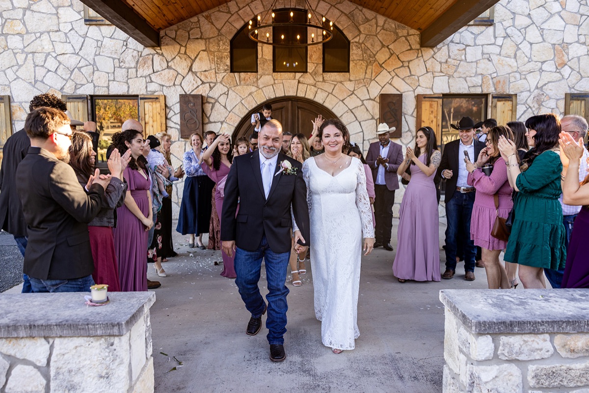 Wedding recessional under the stone arch at Sendera Springs in Kerrville, Texas, photographed by GR Weddings